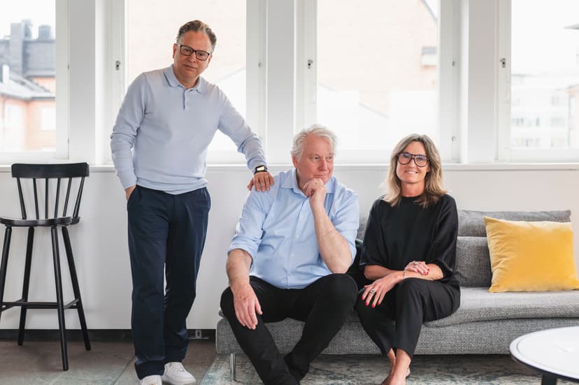 Tre av Noväntas konsulter står och sitter tillsammans i en soffa vid ett ljust fönster.